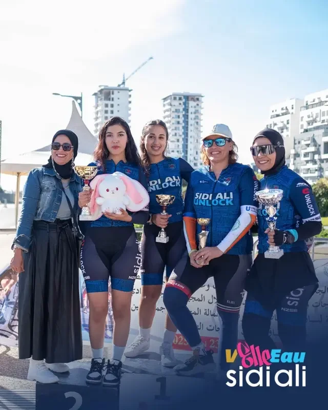 SIDI ALI UNLOCK cyclists holding trophies at a podium presentation